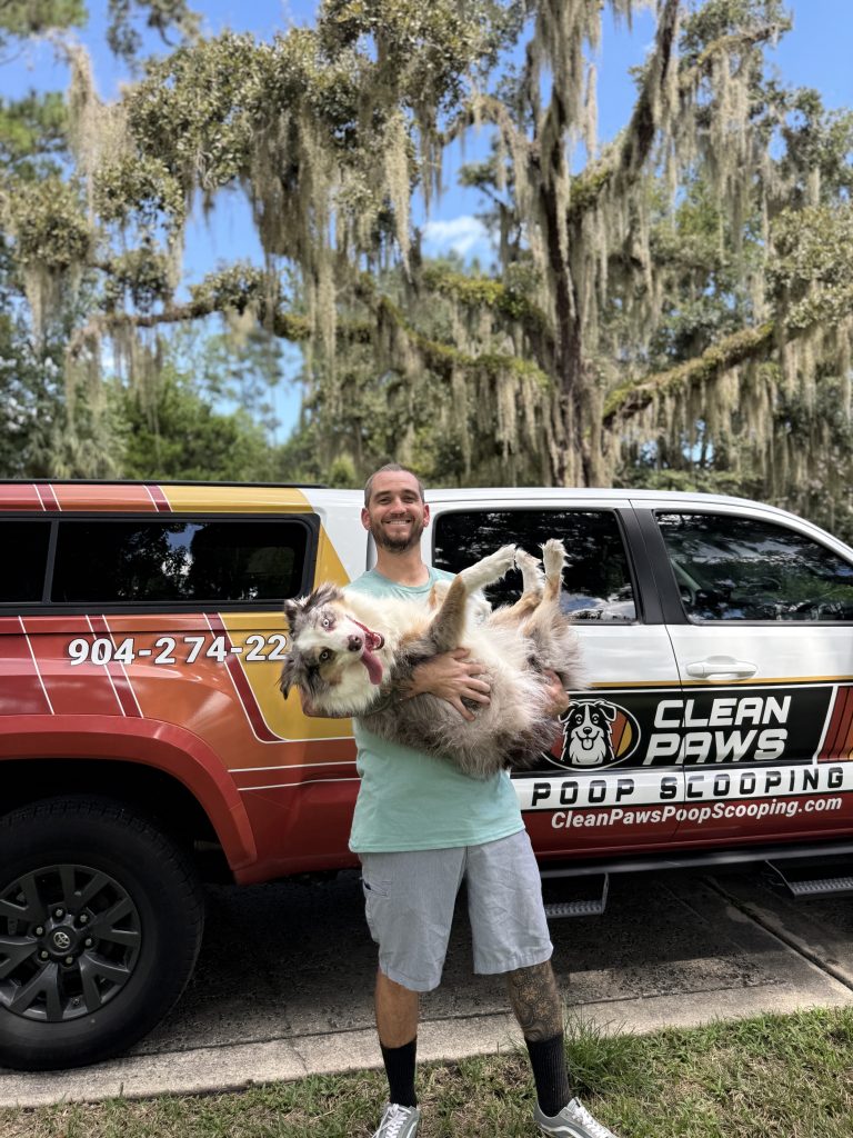 Kevin and Opal Kevin from Clean paws holding his australian shepherd in front of his truck